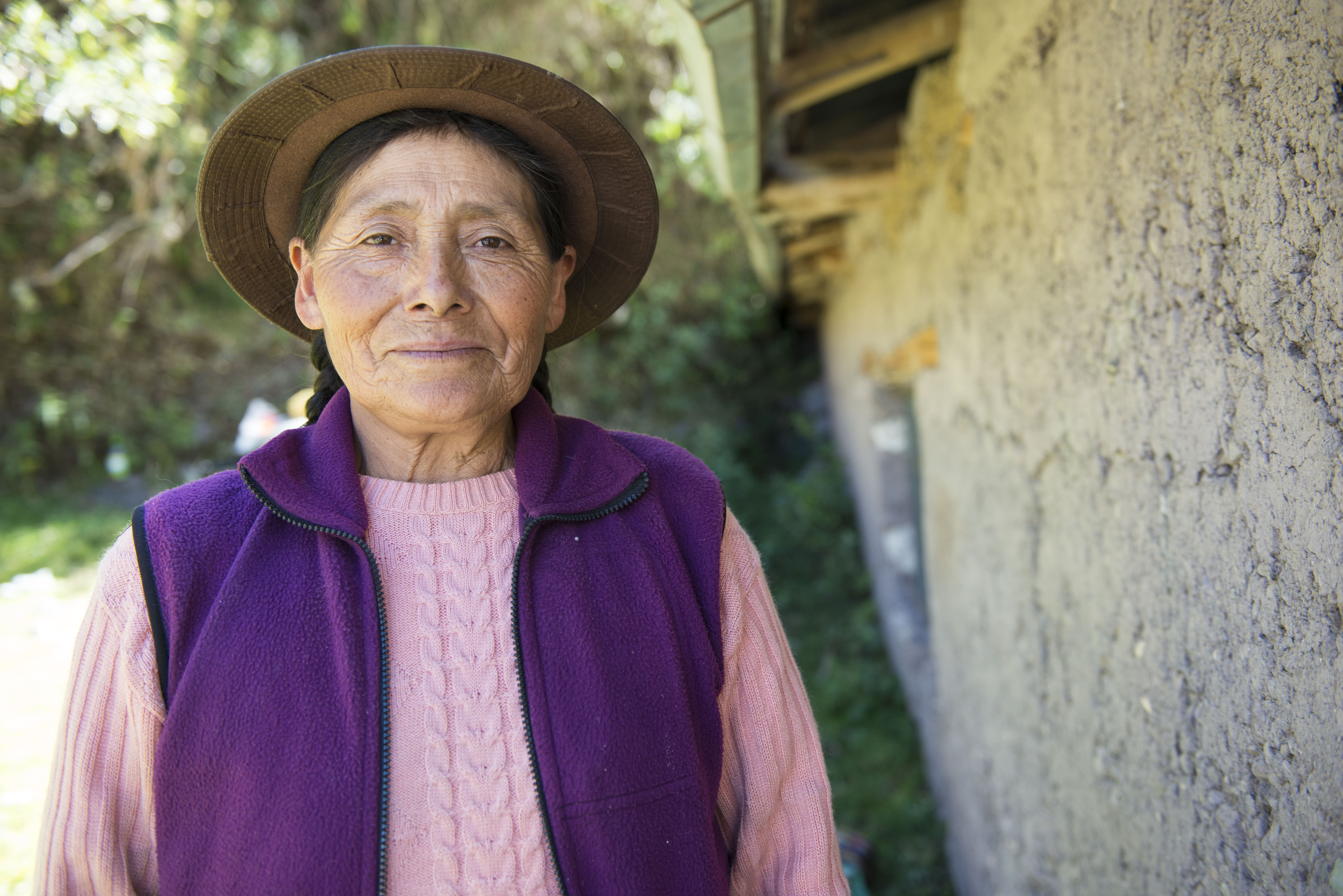 A Quechua woman stands next to her church.